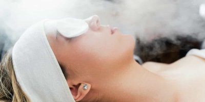 Žena s kosmetickou čelenkou a tampony na očích 