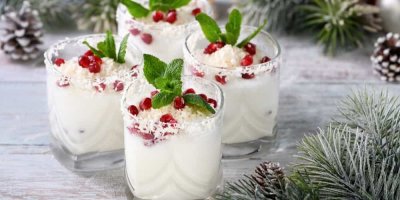 Skleničky s bílým vánočním mojitem ozdobeným zrny granátového jablka, strouhaným kokosem a meduňkou