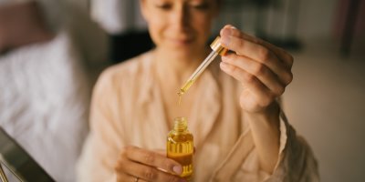 Člověk nabírá pleťový olej kapátkem