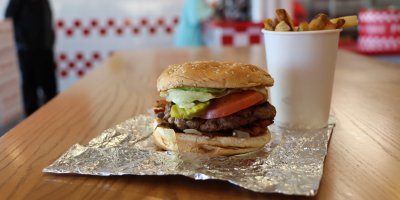 Burger a hranolky na stole restaurace