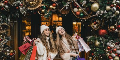 Dvě dívky s nákupními taškami pod vánoční výzdobou