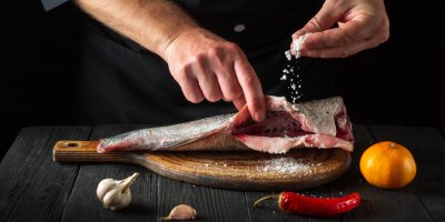 Profesionální kuchař solící rybu