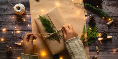 Člověk balí dárek do hnědého papíru