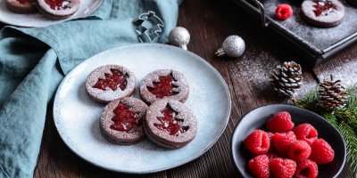 Kakaové linecké cukroví na talíři, vedle maliny v misce