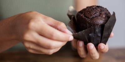 Ruka oddělává obal z muffinu