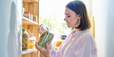 Žena otevírá sklenici, ve které je bobkový list