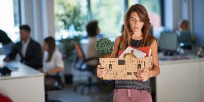 Mladá smutná žena si stěhuje věci z kanceláře