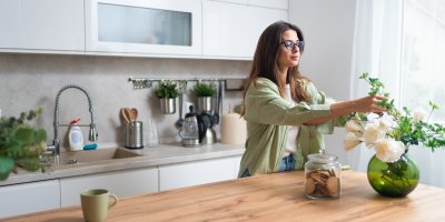 Žena dává květiny do vázay