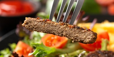 Rostlinný burger napíchnutý na vidličce