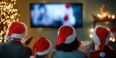 Lidé v santovských čepicích sledují televizi