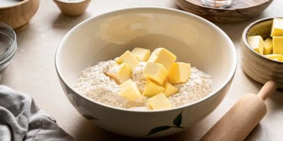 Kostky másla v míse s moukou