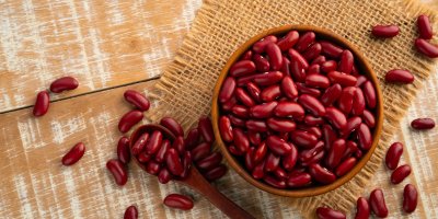 Červené fazole v misce i okolo ní