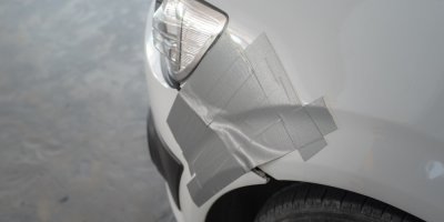 Poškozené auto přelepené šedou polyethylenovou páskou