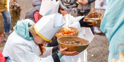 Děti převlečené za Kašpara, Melichara a Baltazara drží v rukou ošatky s ořechy a jablky