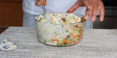 Člověk promíchává ingredience na salát s majonézou