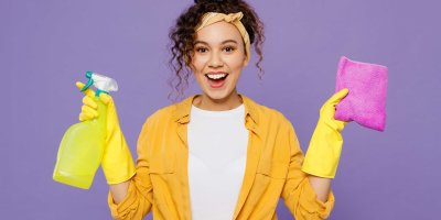 Dívka se usmívá a v ruce drží čisticí prostředky