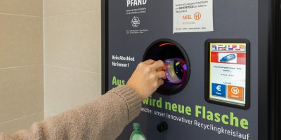 Žena vhazuje PET lahev do recyklačního boxu