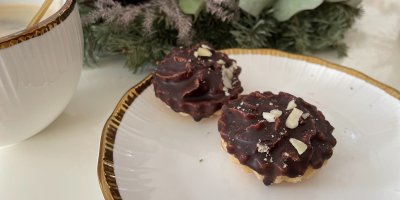 Dva ořechové košíčky na talíři, v pozadí vánoční dekorace