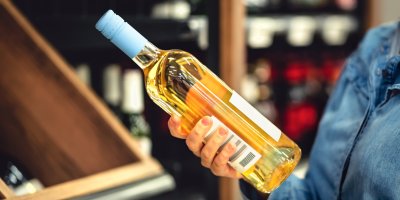 Žena drží lahev vína