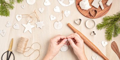 Člověk navléká provázek na ozdoby vyrobené z bílé hmoty