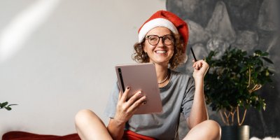 Žena v santovské čepici píše na tabletu