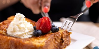 Žena ukrajuje příborem dezert