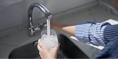 Žena napouští vodu z kohoutku