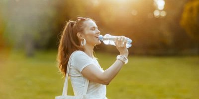 Žena pije balenou vodu