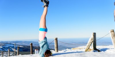 Žena dělá stojku na Sněžce