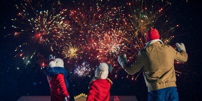 Otec a jeho dvě malé děti se dívají na ohňostroj