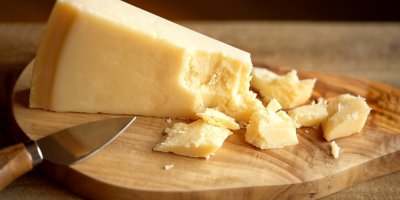 Sýr Grana Padano na dřevěném prkénku