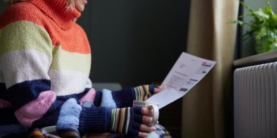 Žena ve svetru a rukavicích drží fakturu