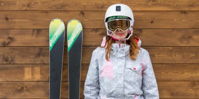 Žena stojí vedle lyží