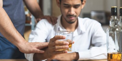 Muž brání druhému v pití alkoholu