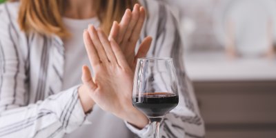 Žena odmítá sklenici vína