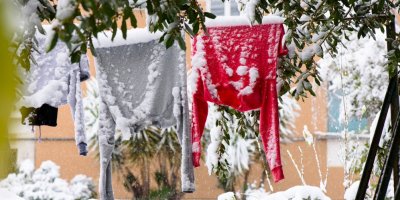 Dva zasněžené svetry na šňůře venku