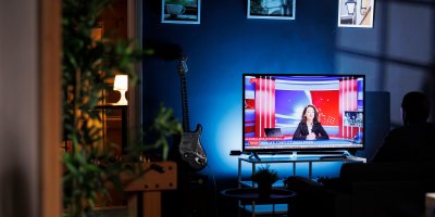 Muž sleduje potmě televizi