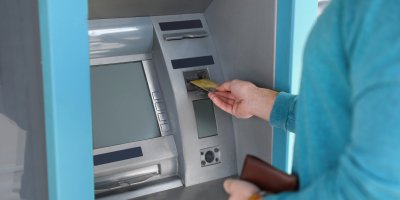 Muž vkládá kartu do bankomatu
