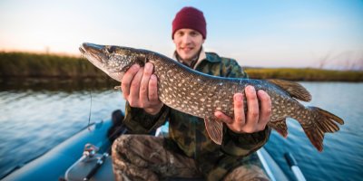Muž drží v rukou ulovenou rybu