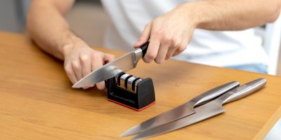 Muž ostří nůž na ostřiči