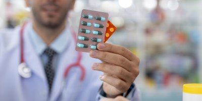 Muž drží v ruce platíčka s léky