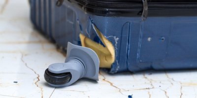 Poničený kufr, ulomené kolečko
