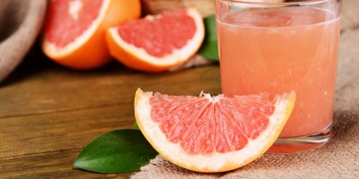 Rozkrojený grep a grapefruitová šťáva ve sklenici