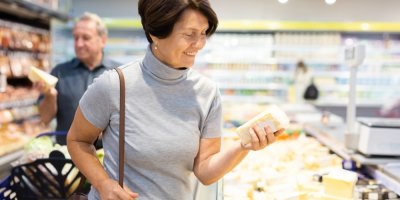 Žena v supermarketu drží v ruce sýr