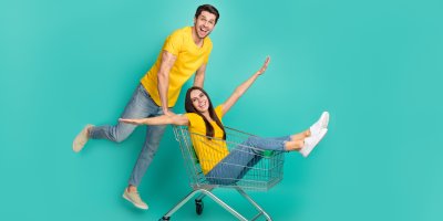 Muž veze ženu v nákupním vozíku