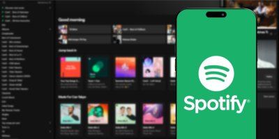 Logo aplikace Spotify na obrazovce mobilního telefonu, v pozadí webové stránky Spotify na monitoru počítače