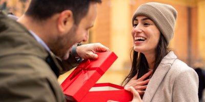 Muž dává ženě dárek v červené krabici
