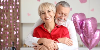 Starší zamilovaný pár, v pozadí balonky ve tvaru srdce