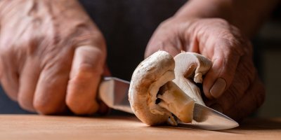 Ruka krájí nožem žampion