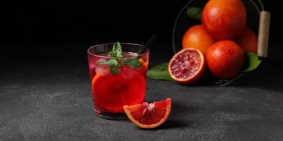 Koktejl s červeným pomerančem v pozadí
